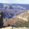 Weitwinkelaufnahme eines Canyon-Panoramas mit geschichteten Felsformationen und Vegetation im Vordergrund.