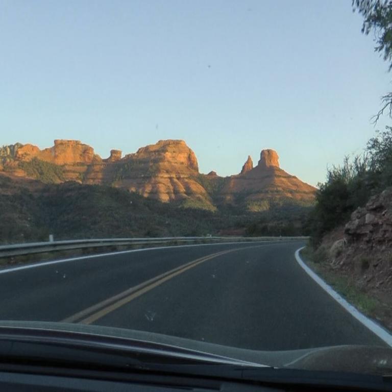 Eine Autobahn führt durch eine Landschaft mit charakteristischen, erhabenen Felsformationen im Hintergrund.