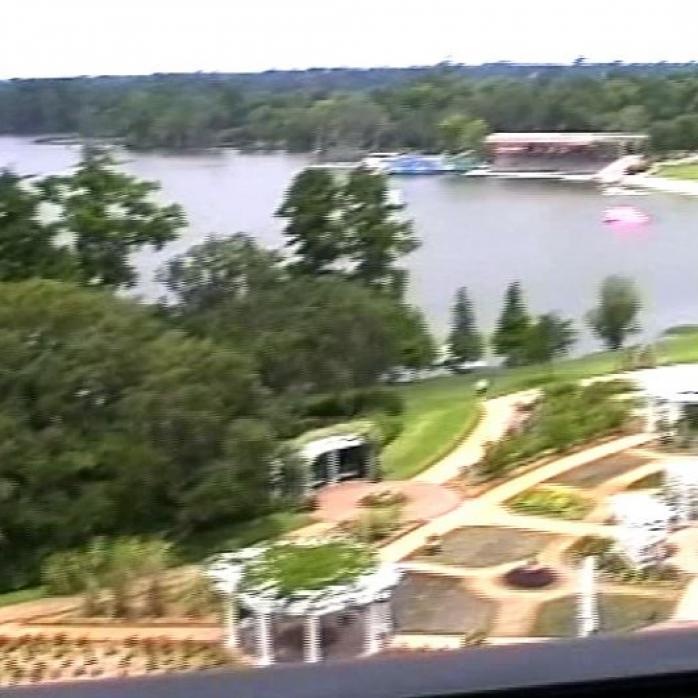 Luftaufnahme eines großen Sees mit einem angrenzenden, gepflegten Park- und Resortbereich.