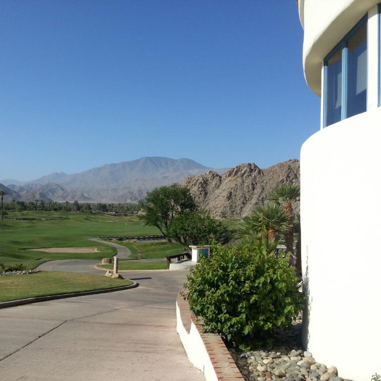 Aussicht vom Gebäude auf einen gepflegten Golfplatz mit Blick auf eine Bergkette.