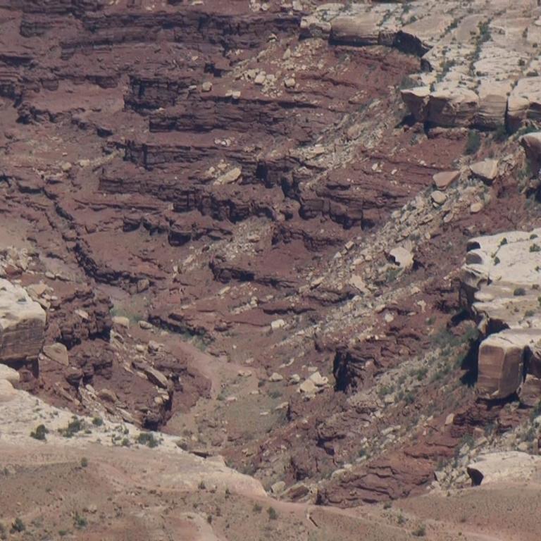 Panorama einer ausgedehnten, trockenen Schlucht mit sichtbaren geologischen Schichtungen.
